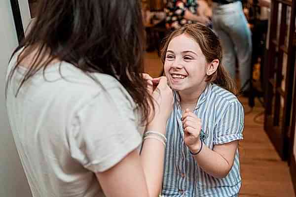 Girl laughing during conversation indoors.