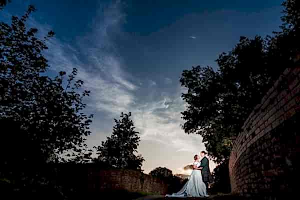 Couple embracing at sunset, dramatic sky.