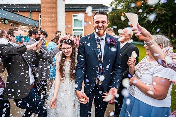 Joyful wedding confetti celebration outdoors.