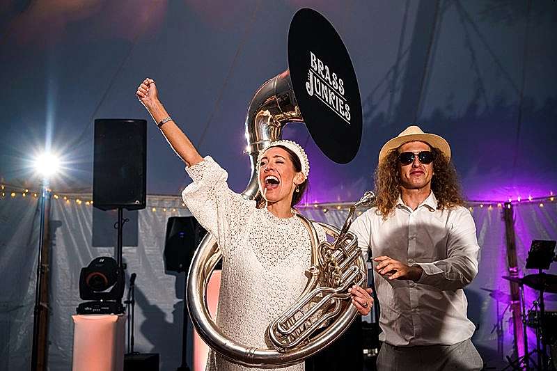 Musicians performing live at an event with brass instruments.