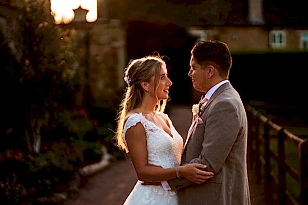Couple in wedding attire enjoying a sunset moment.