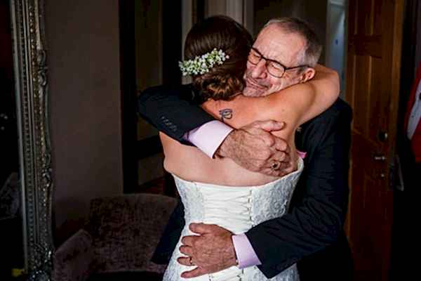 Bride embracing elder in heartfelt wedding hug.