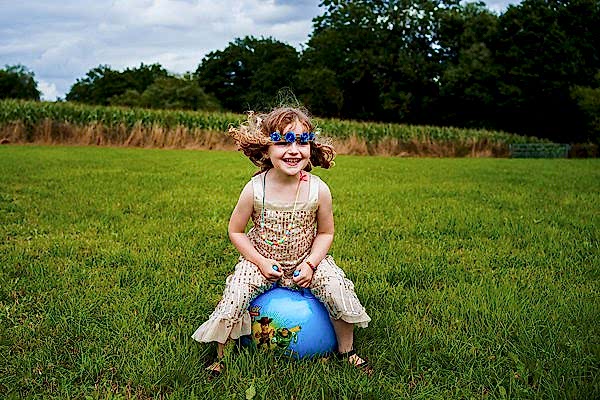 Child playing on ball in field