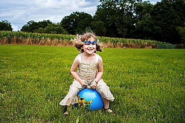 Child playing on ball in field