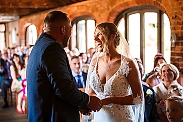 Joyful bride and groom holding hands at wedding.