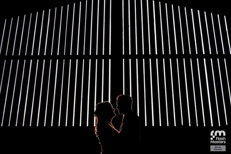 Silhouetted couple against illuminated vertical lines