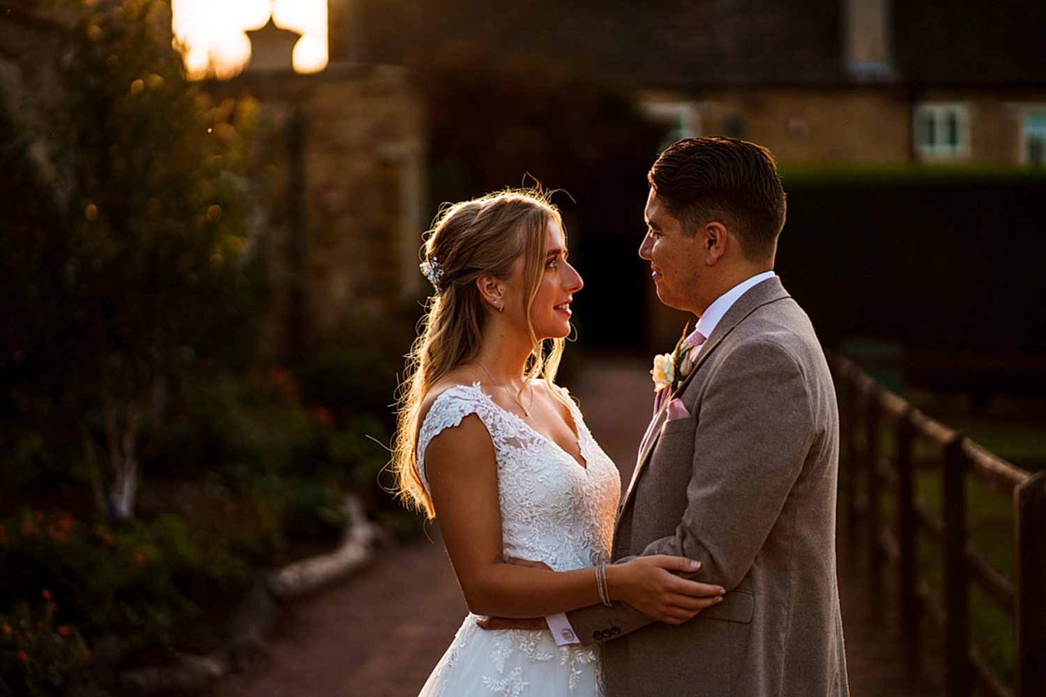 Couple in wedding attire during sunset ceremony.