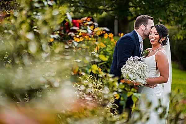 Couple embracing at garden wedding ceremony.