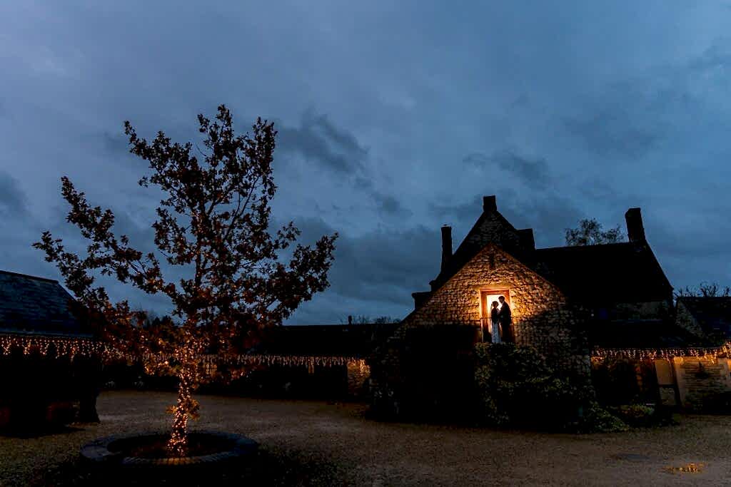 Twilight at illuminated rustic cottage with fairy lights.