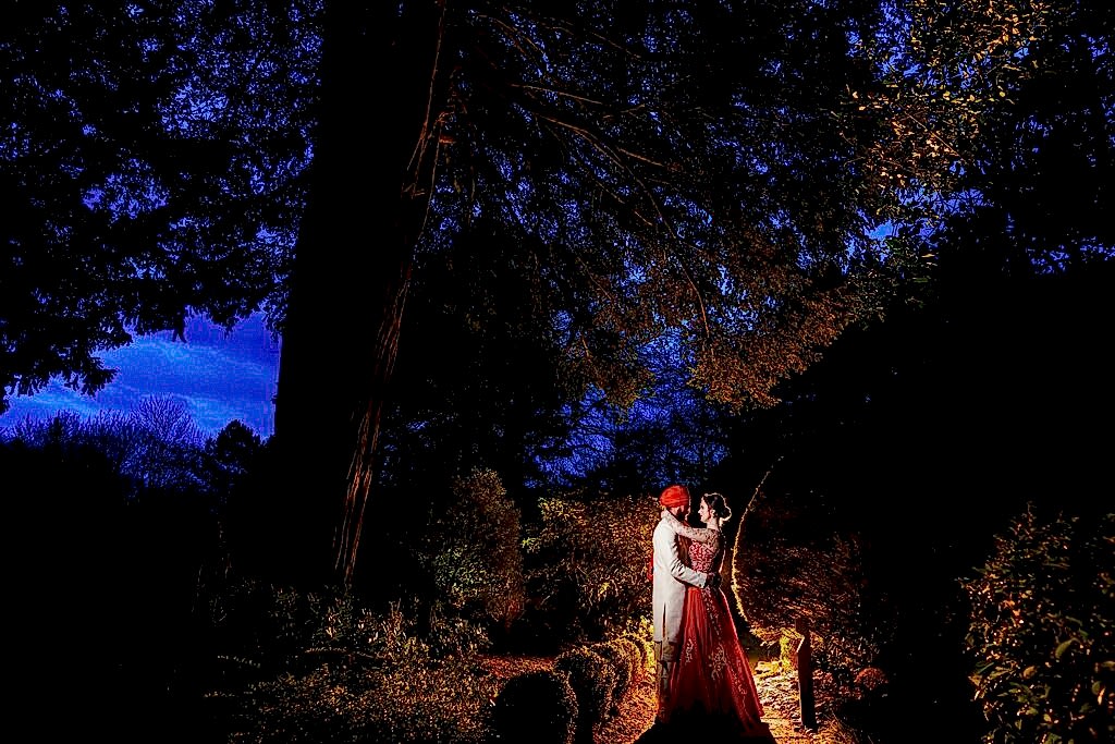 Couple in evening attire outdoors at night.