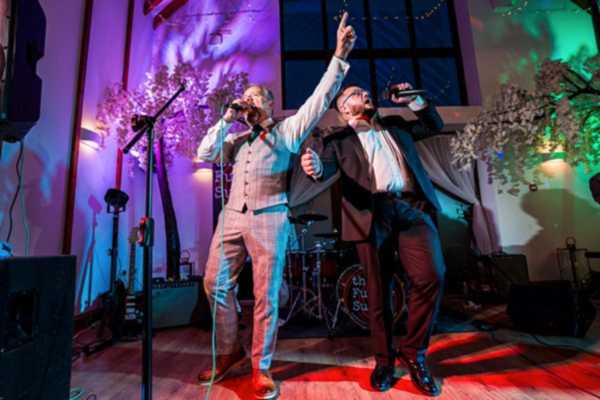 Two singers performing at a live music event.