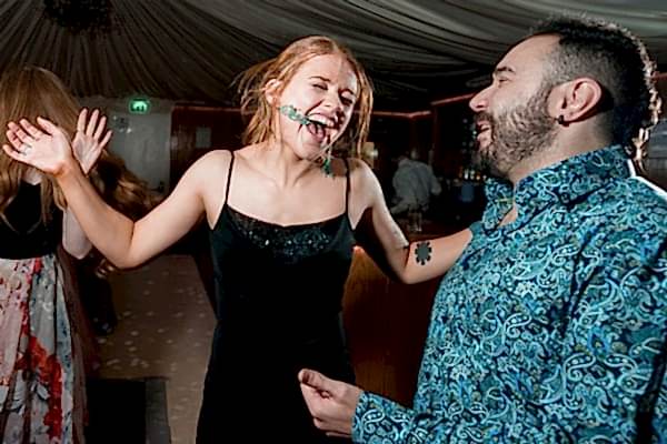 People laughing and dancing at party.
