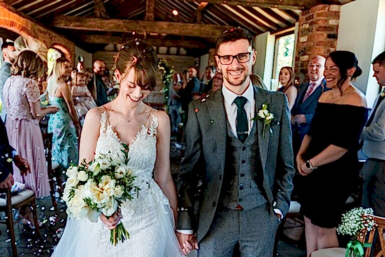 Happy bride and groom at wedding ceremony aisle.