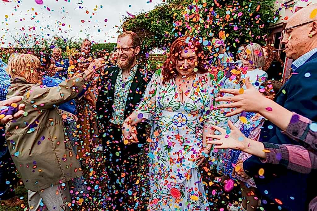 Couple surrounded by colourful confetti celebration.