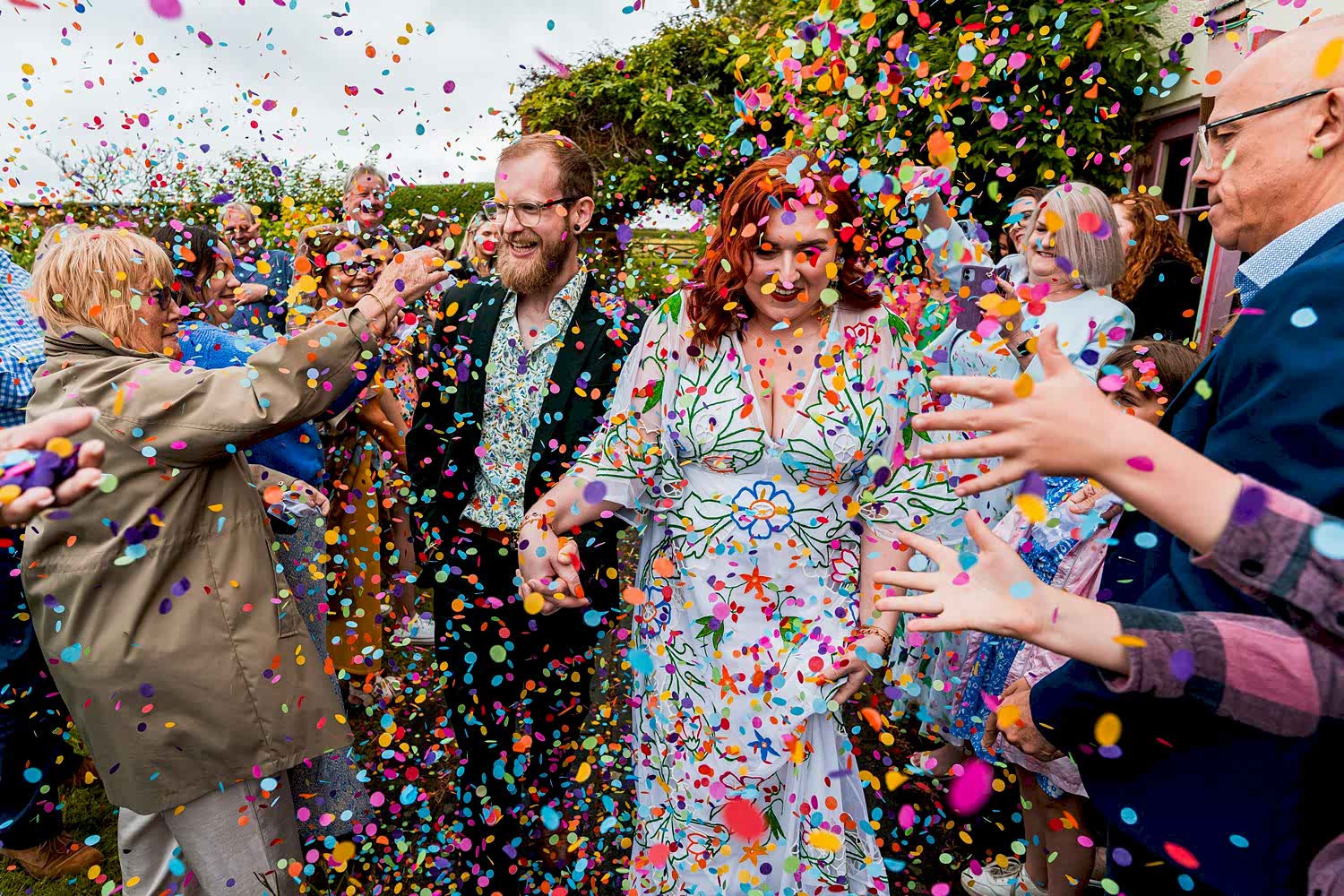Couple surrounded by colourful confetti celebration.