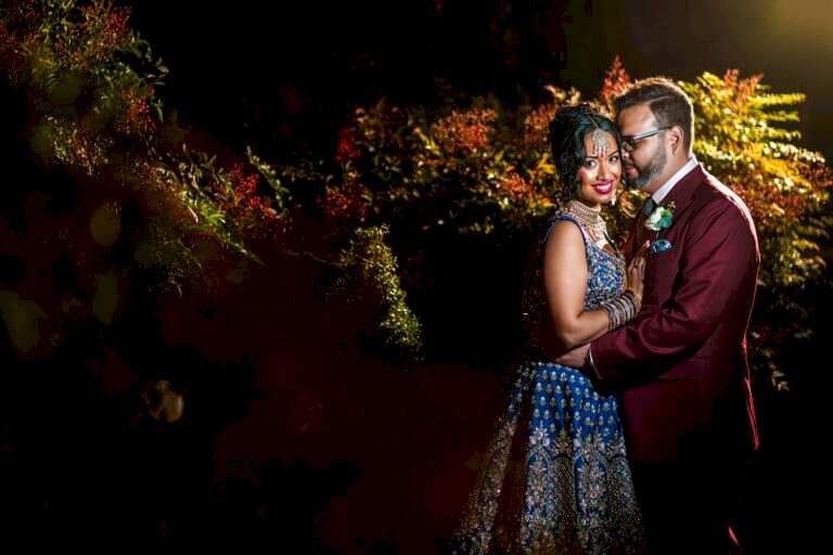 Couple posing in elegant attire at night.