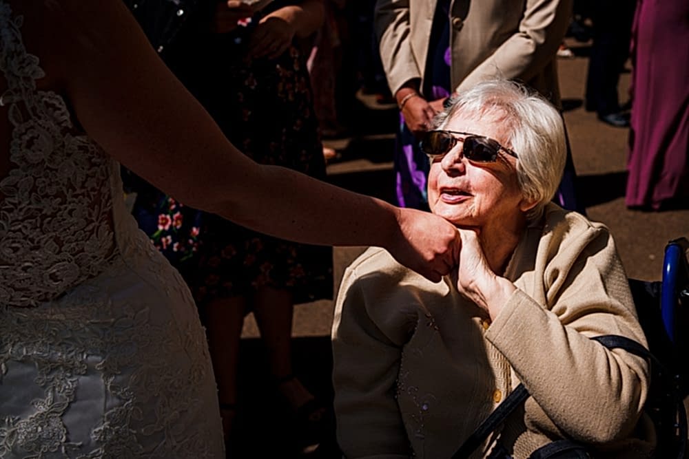 Bride greets elderly woman in wheelchair