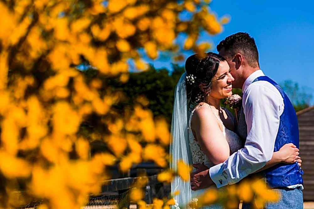 Bride and groom embracing on a sunny day.