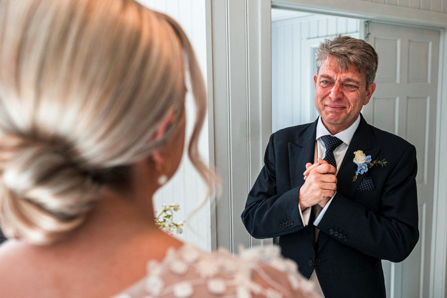 Tearful father sees bride before wedding ceremony.
