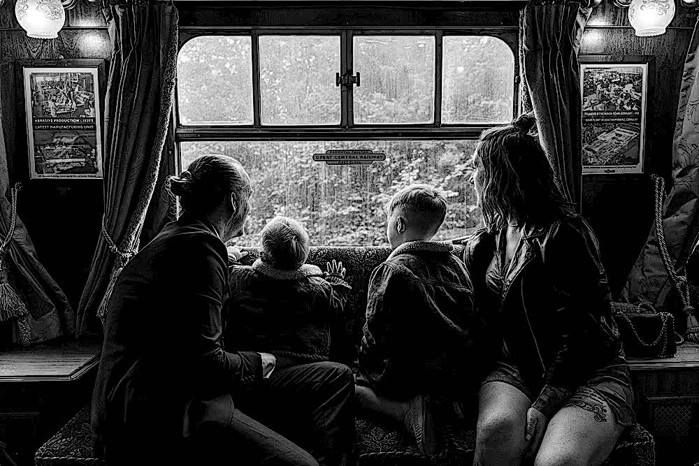 Family looking out train window together.