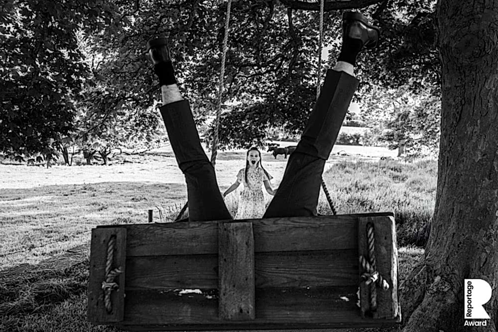 Person upside down on swing, surprised child watching.