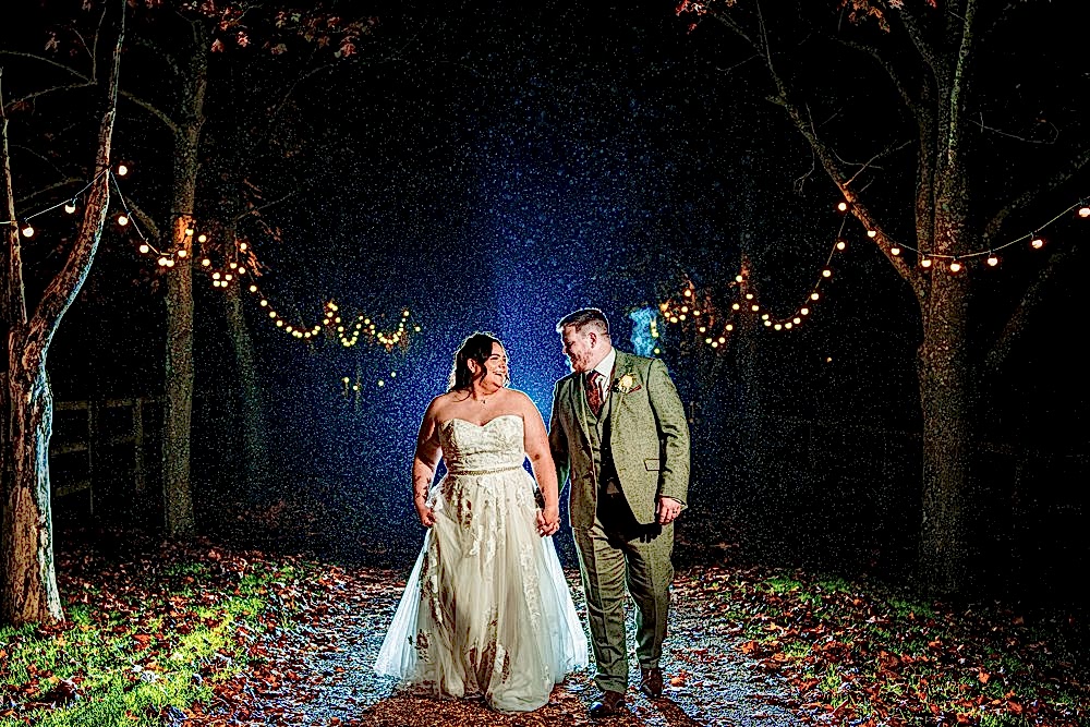 Rainy evening wedding couple under fairy lights