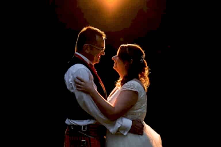 Couple embraces in warm sunset glow.