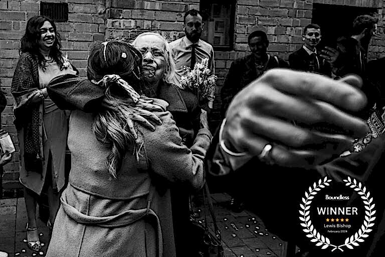 Elderly woman hugging smiling friend at celebration event.