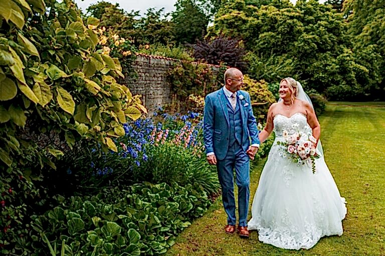 Bride and groom walking in garden