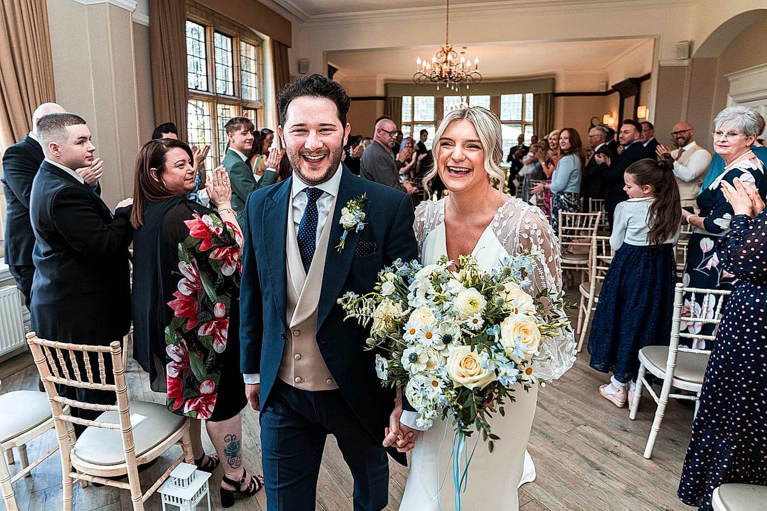 Bride and groom walking down the aisle, smiling.