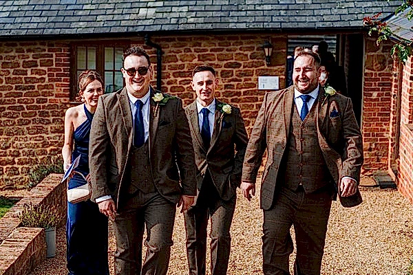 Happy people walking to a rustic venue.