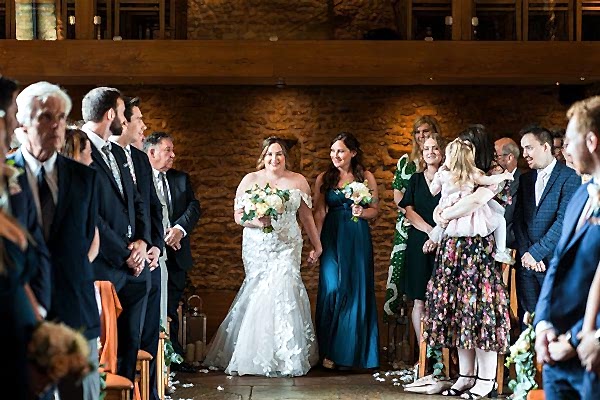 Brides walking down aisle at wedding ceremony.