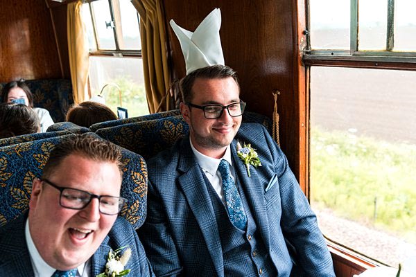 Laughing men in suits on vintage train.