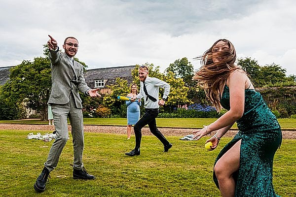 Group playing on grass during a wedding.