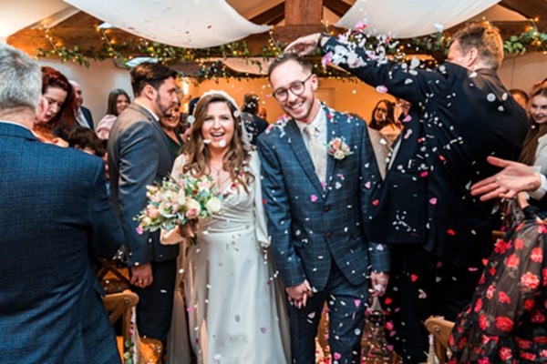 Happy couple showered with confetti at wedding.