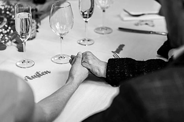 Couple holding hands at a table setting