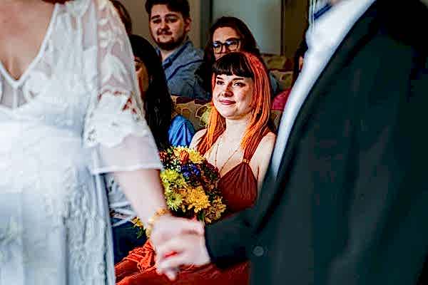 Wedding ceremony with guests and colourful bouquet.