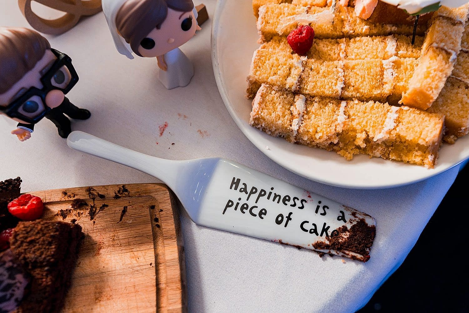 Cake slices with wedding figurines on table.