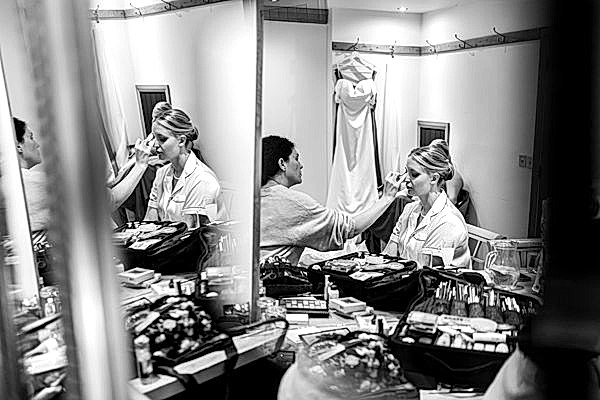 Bride getting makeup done before wedding.