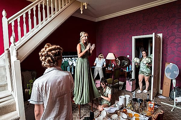 Bridesmaids getting ready in a lively room.
