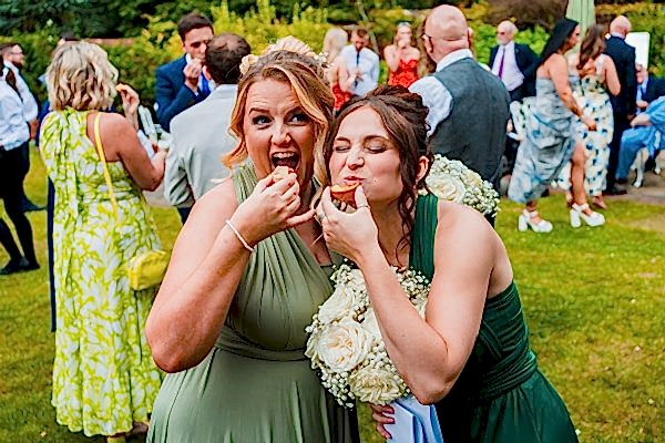 Guests enjoying wedding cupcakes in garden setting.
