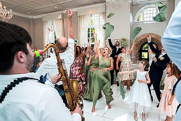Wedding guests dancing and celebrating with joy.
