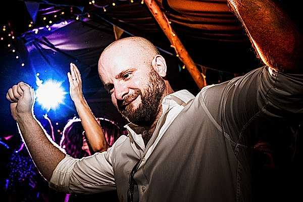 Man dancing at a party with bright lights