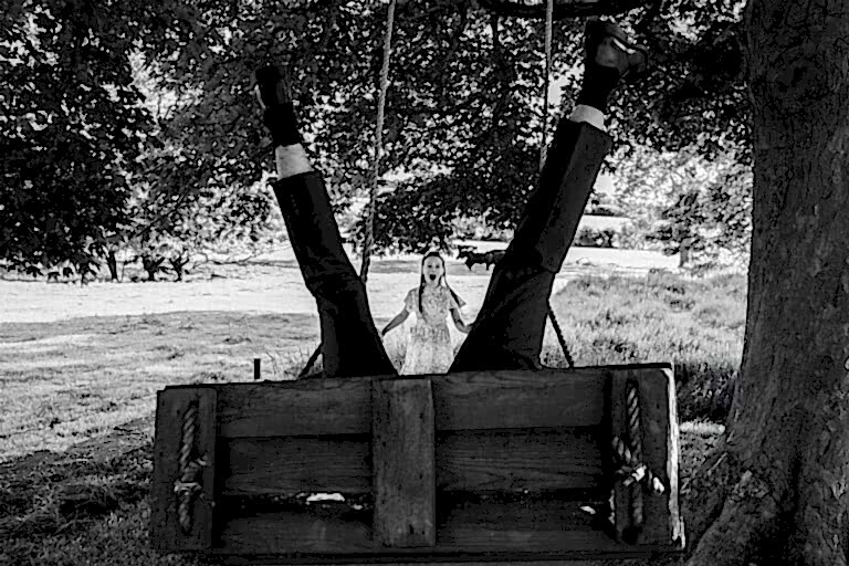Man upside down on swing, surprised woman watching.