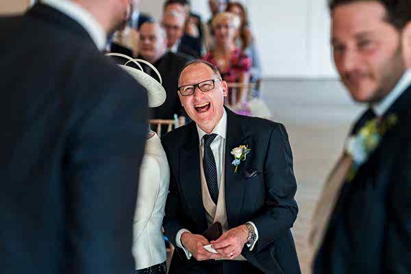 Laughing man at formal event.