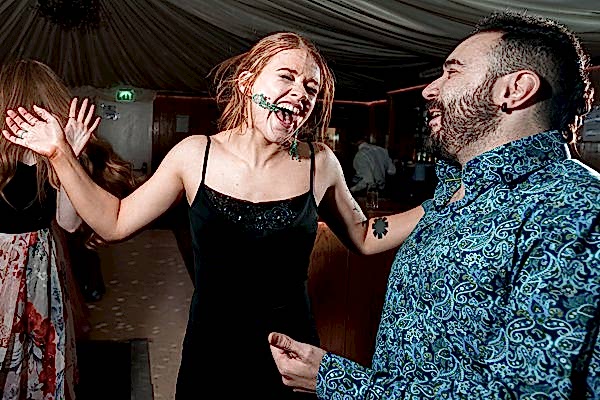 People laughing and dancing at a party tent.