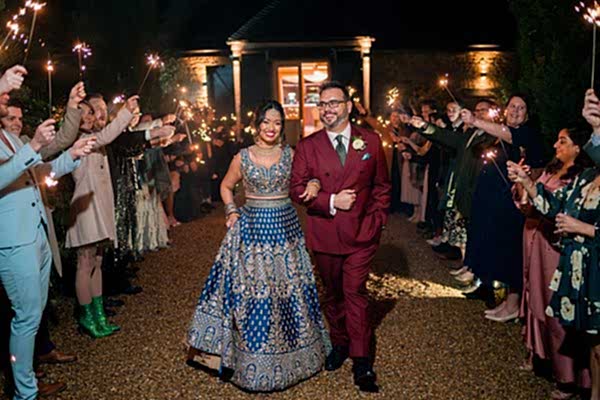 Couple celebrating wedding with sparklers at night.