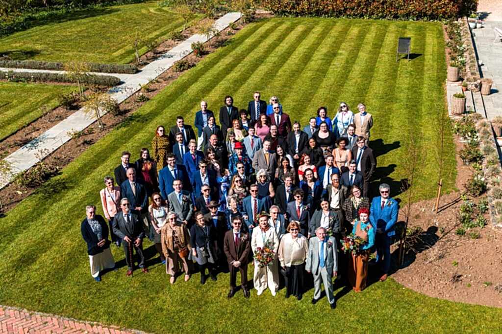 Large group gathered in garden for a wedding.