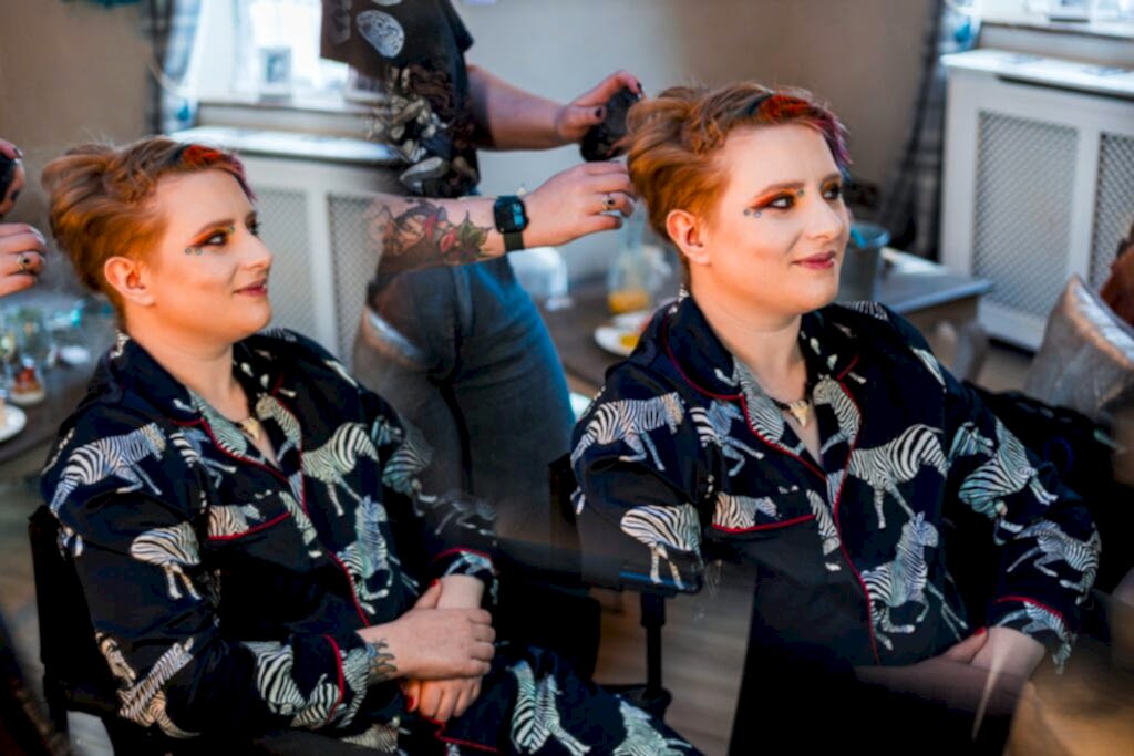 Person styled with short hair and zebra-pattern outfit.
