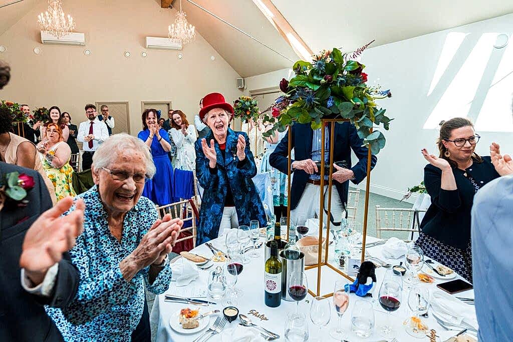 Guests applauding at a joyful gathering.